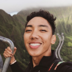 a person holding a rail and a large mountain behind them