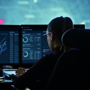 Person at bank of computer monitors