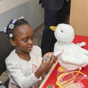 Young black female patient playing with My Special Aflac Duck.