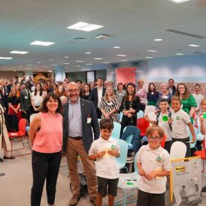 Adults and children in a classroom posing for the camera