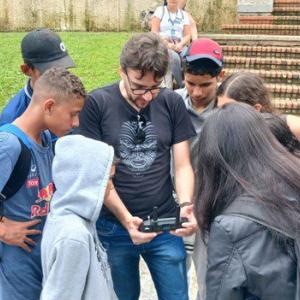 Students in a circle around an adult, looking at something