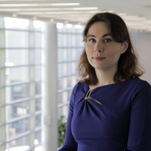 A person in an office building, a large wall of windows behind them