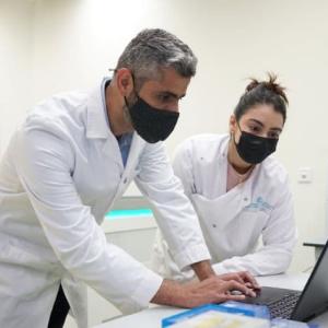  Dr. Ahmad Abou Tayoun and another person using a laptop