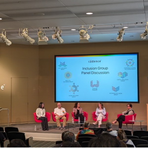 five people on a stage in red chairs with a projection screen behind them