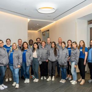 group of people posing for group picture with gray jackets on