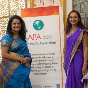 Two women next to Asia Pacific Association sign 