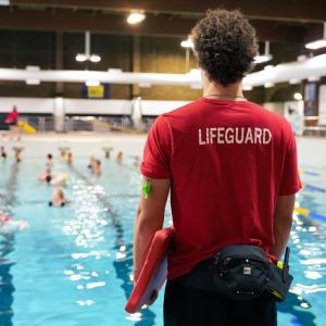 A life guard looking out over a large indoor pool with swimmers.