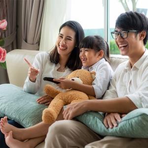 Asian American family seated on a couch.