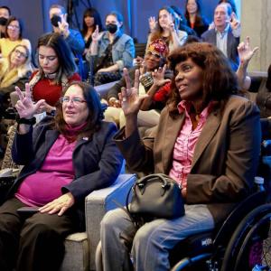 A group of people practicing sign language.