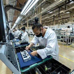 Employees assembling electronics in a warehouse.