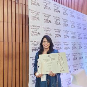 Kavita Sah Holding the Mahatma Award.