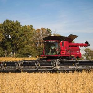 A large red farm harvester in a field