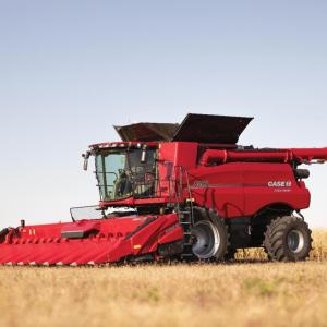 A large red farm harvester in a field