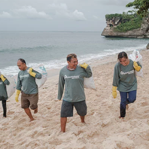 Four volunteers picking up trash on a beach
