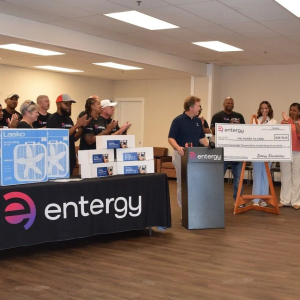 An oversized check being presented, a group clapping