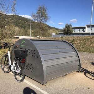 A bike storage container in a parking lot.