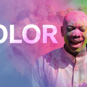 COLOR: A person in a white shirt with colored powder covering them