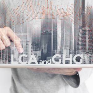 abstract of person holding a city on a board pointing to words "lca or ghg"