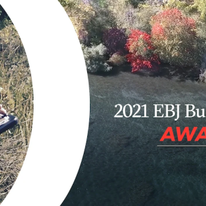 Person writing on clipboard with text that reads: 2021 EBJ Business Achievement Awards Winner