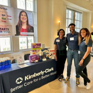Three people posed at a Kimberly-Clark booth