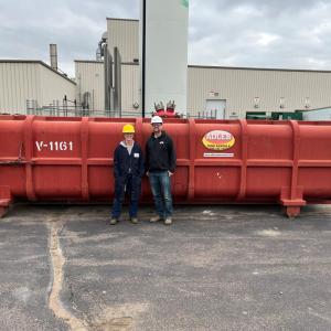 Two people in front of a tank