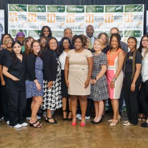 Group of people in front of a Healthy Houston Collective banner