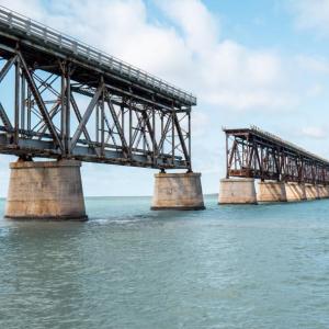 An incomplete bridge over a large body of water.