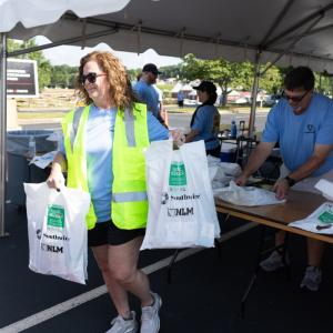 Southwire volunteer holding bags of school supplies