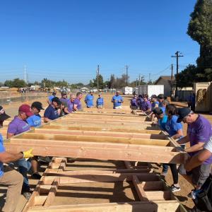 Volunteers putting up a side of a house