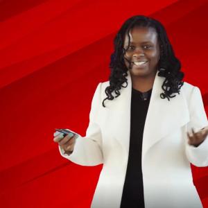 A person smiling with their hands out in front of a red background
