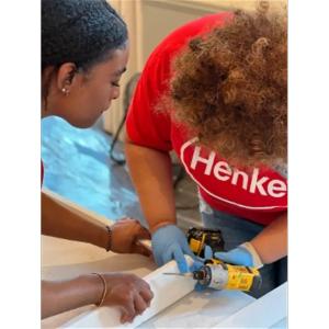 Two people screwing boards together.