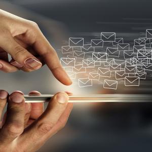 Reflection of someone using a mobile phone with envelope illustrations 