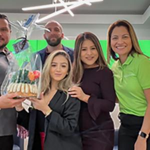 Employees holding a cake
