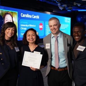 Four people smiling and standing together