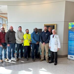 A group posed in the medical center with a doctor.