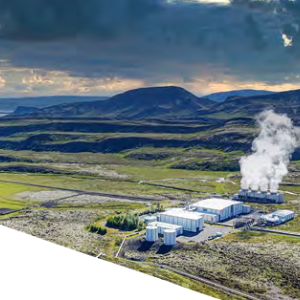Aerial view of a hilly landscape. Large buildings and roads to them are central in an open grassy area. Steam coming from one area.