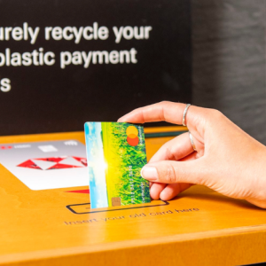 A person depositing a credit card into a recycling machine