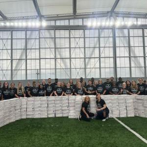 Volunteers posed behind stacks of finished care boxes.