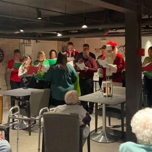 A group singing to others seated.