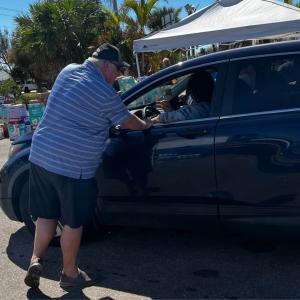 a person talking to another in the front seat of a car