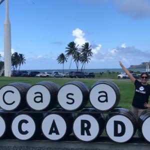 Jessica outside next to barrels spelling out "Casa Bacardi" Wind turbines in a grassy area behind her. Image courtesy of Page