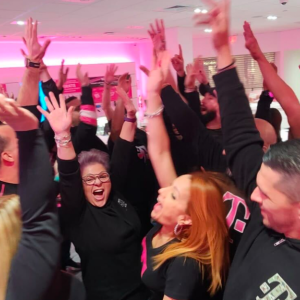 A group pf people jumping, smiling, hands in the air.