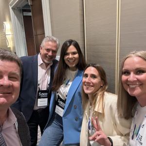 Five people smiling and posing for the camera