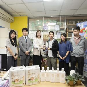 6 people standing behind products, holding an award