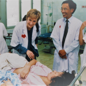 Smiling healthcare workers next to a patient in a bed