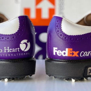 Purple and white bowling shoes, one saying "Heart to Heart International" and the other saying "FedEx Cares"