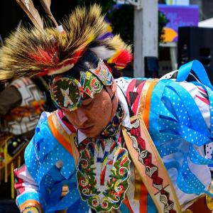 A person in ceremonial garments dancing.