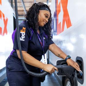 FedEx employee charging an electric vehicle 