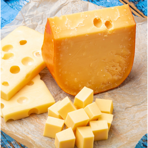 A chunk of cheese on a board.