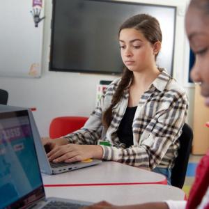 children working on laptops